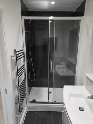 a bathroom with a shower and a sink at Optimal Homes in Harold Wood
