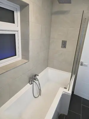 a bathroom with a sink and a bath tub at Optimal Homes in Harold Wood