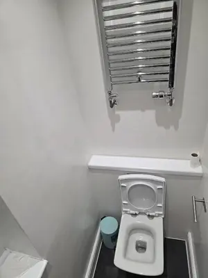 a small bathroom with a toilet and a window at Optimal Homes in Harold Wood