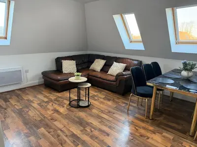 a living room with a couch and a table at Two-Bedroom Attic House in Colchester