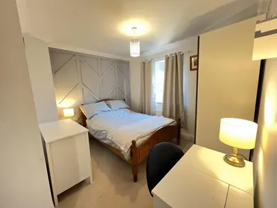 a small bedroom with a bed and a window at Siskin House in Wickham Market