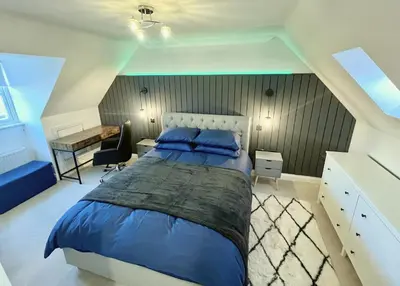 a bedroom with a large bed and a desk at Siskin House in Wickham Market
