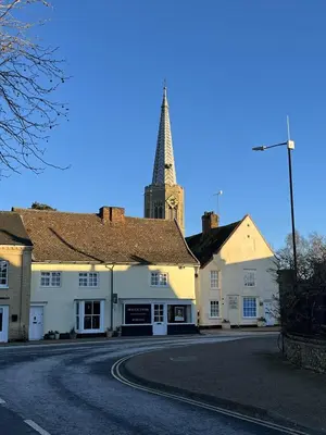 a church with a clock tower in a town street at Siskin House in Wickham Market