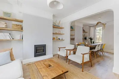 a living room with a fireplace and a table at Stunning 2Bed Central Home in Cambridge