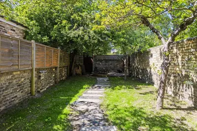 an alley with a brick wall and a tree at Stunning 2Bed Central Home in Cambridge