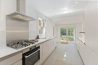 a white kitchen with a stove and a sink at Stunning 2Bed Central Home in Cambridge