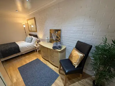 a bedroom with a bed and a desk and a chair at Large 5BR House with FREE Parking and WiFi plus Garden in Basildon, Essex in Basildon