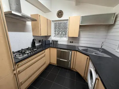 a small kitchen with a sink and a stove at Large 5BR House with FREE Parking and WiFi plus Garden in Basildon, Essex in Basildon