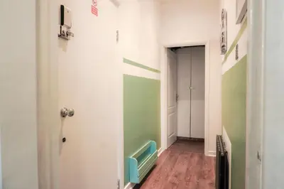 a hallway with green and white walls and a blue chair at 1BR Super King sized Apartment Contractor friendly - Free Parking! in Southend-on-Sea