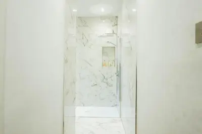 a bathroom with a shower with white marble at 1BR Super King sized Apartment Contractor friendly - Free Parking! in Southend-on-Sea
