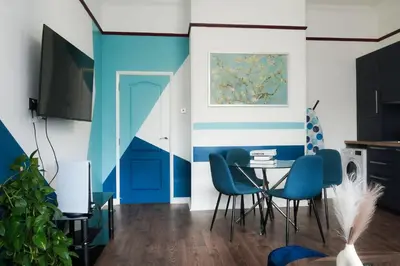 a dining room with blue and white walls and a table at 1BR Super King sized Apartment Contractor friendly - Free Parking! in Southend-on-Sea