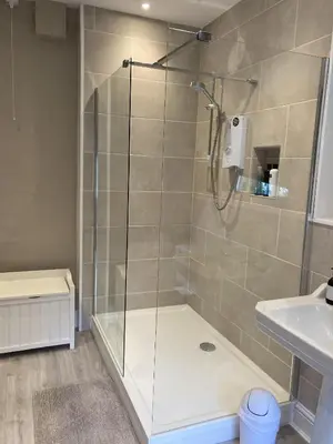 a shower with a glass door in a bathroom at Grange Farm in Thetford