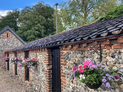 a brick building with flower boxes on it at Grange Farm in Thetford