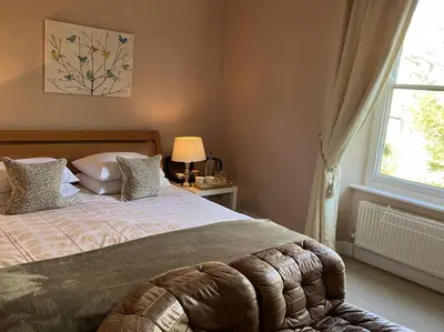 a bedroom with a large bed and a window at Grange Farm in Thetford