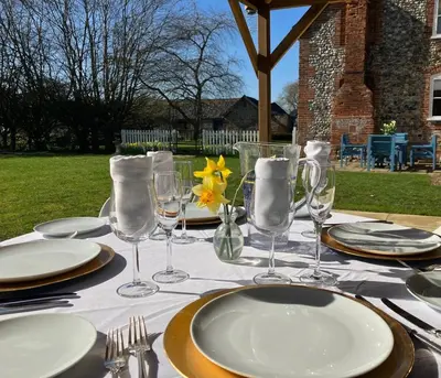 a table with plates and glasses on top of it at Grange Farm in Thetford