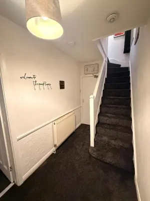 a hallway with stairs and a sign on the wall at Royal 4 Bed House By City Centre in CBG