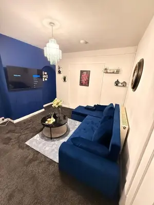 a living room with a blue couch and a table at Royal 4 Bed House By City Centre in CBG