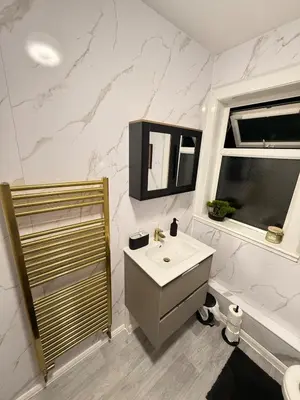 a bathroom with a sink and a mirror and a shower at Royal 4 Bed House By City Centre in CBG