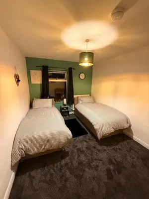 two beds in a room with green walls at Royal 4 Bed House By City Centre in CBG