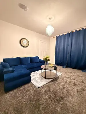 a living room with a blue couch and a table at Royal 4 Bed House By City Centre in CBG