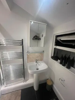 a white bathroom with a sink and a shower at The Emerald Aura Stay By Cambridge Central Station in Cambridge