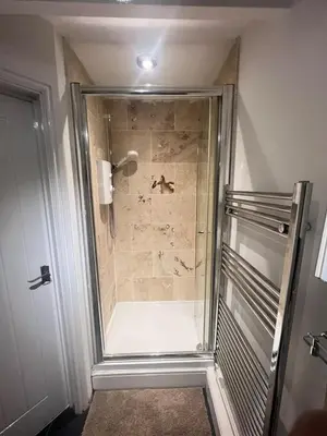 a shower in a bathroom with a glass door at The Emerald Aura Stay By Cambridge Central Station in Cambridge