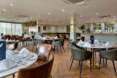 a restaurant with tables and chairs and a bar at Finest Retreats - Heron Luxury Lodge