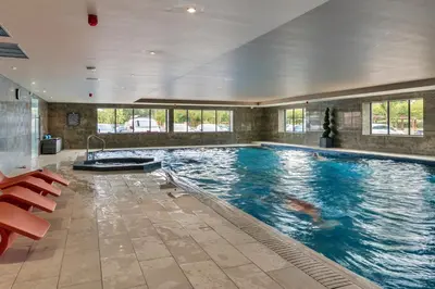 a large swimming pool in a building with a large swimming pool at Finest Retreats - Heron Luxury Lodge