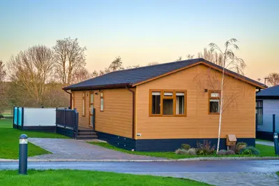 a wooden house with a black roof at Finest Retreats - Heron Luxury Lodge