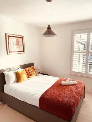 a bedroom with a large bed with a red blanket at Central Cambridge with Free Parking and Pets welcome in Chesterton