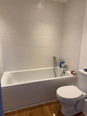a bathroom with a white tub and a toilet at 2 Bed apartment- Laindon in Great Burstead