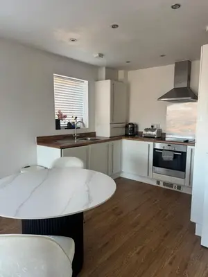 a kitchen with a table and a counter top at 2 Bed apartment- Laindon in Great Burstead