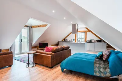 a bedroom with a bed and a living room at Hare View, part of The Garden House in Kenninghall