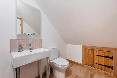 a white bathroom with a sink and a toilet at Hare View, part of The Garden House in Kenninghall