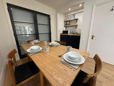 a wooden table with plates and utensils on it at The Coach House in Halstead