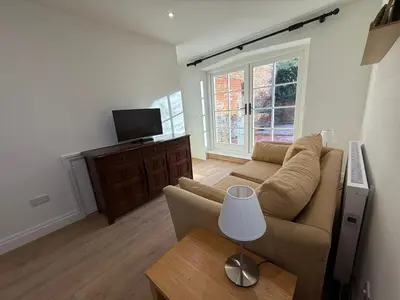a living room with a couch and a tv at The Coach House in Halstead