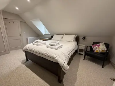 a bedroom with a bed with towels on it at The Coach House in Halstead
