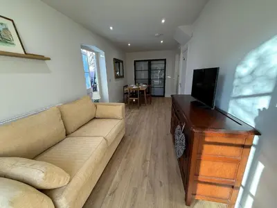 a living room with a couch and a flat screen tv at The Coach House in Halstead