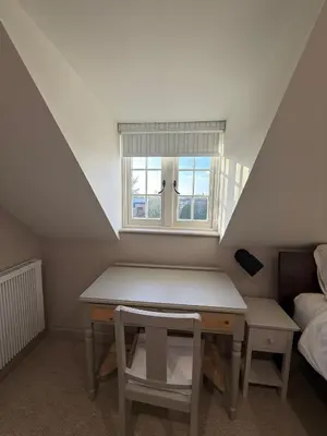 a small room with a table and a window at The Coach House in Halstead
