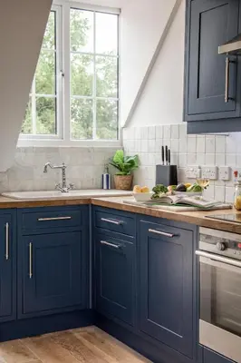 a kitchen with navy blue cabinets and a sink at 1 Quay Cottage in Bawdsey