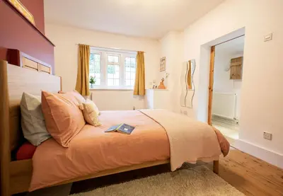 a bedroom with a bed with a book on it at 1 Quay Cottage in Bawdsey