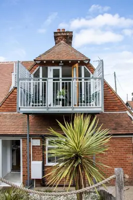 a house with a balcony on top of it at 1 Quay Cottage in Bawdsey