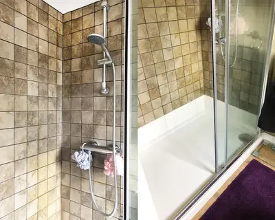 a shower with a glass door and a tub at 'The Artist's Loft' - Studio Flat in Cambridge in Cambridge