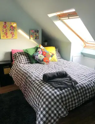a bed with a checkered blanket in a room at 'The Artist's Loft' - Studio Flat in Cambridge in Cambridge
