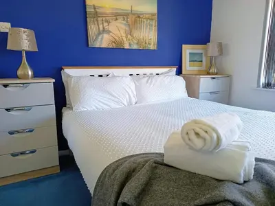 a bedroom with a white bed with a towel on it at Bungalow with a view in Kirby Cross