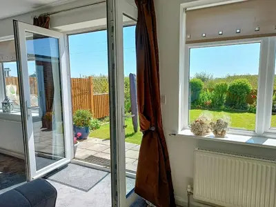 a room with sliding glass doors with a view of a yard at Bungalow with a view in Kirby Cross