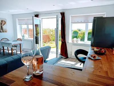 a living room with a table with wine glasses on it at Bungalow with a view in Kirby Cross