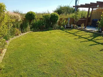 a yard with a grassy lawn with a pergola at Bungalow with a view in Kirby Cross