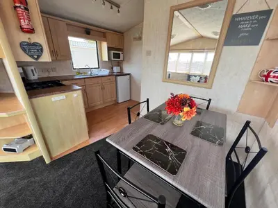 a kitchen with a table with a vase of flowers on it at Rohannah A and C Ultimate Retreat in Colchester