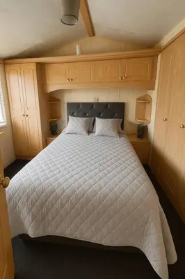 a bedroom with a large white bed with wooden cabinets at Rohannah A and C Ultimate Retreat in Colchester